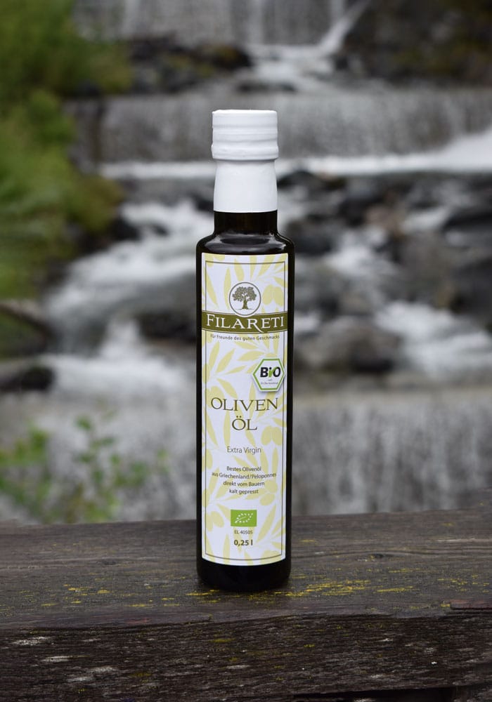 Griechisches Olivenöl und im Hintergrund ist ein Wasserfall