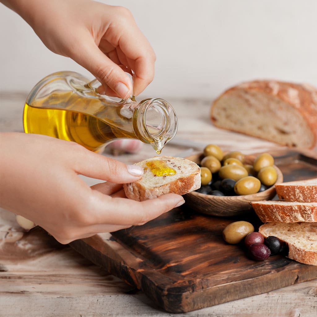 Brot wird mit Olivenöl beträufelt