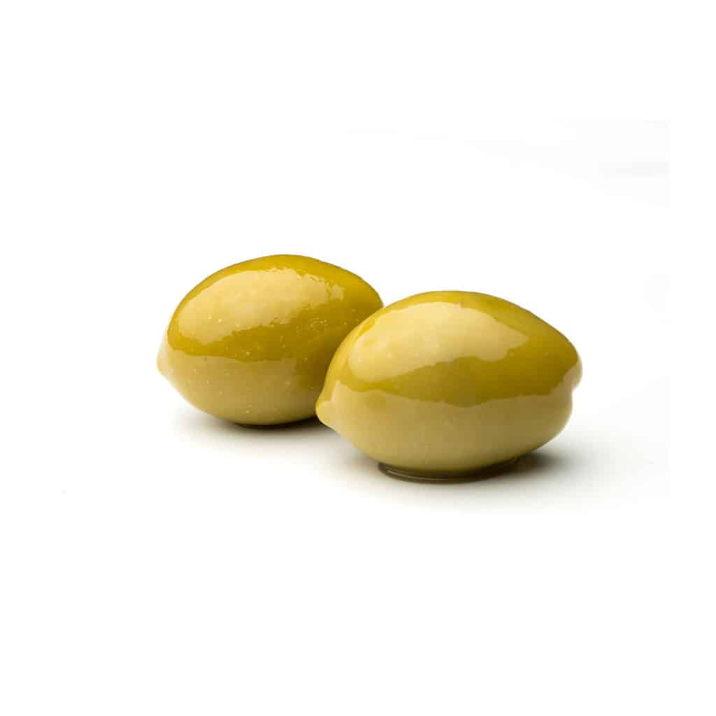 Zwei grüne Oliven, die auf einen weißen Boden liegen
